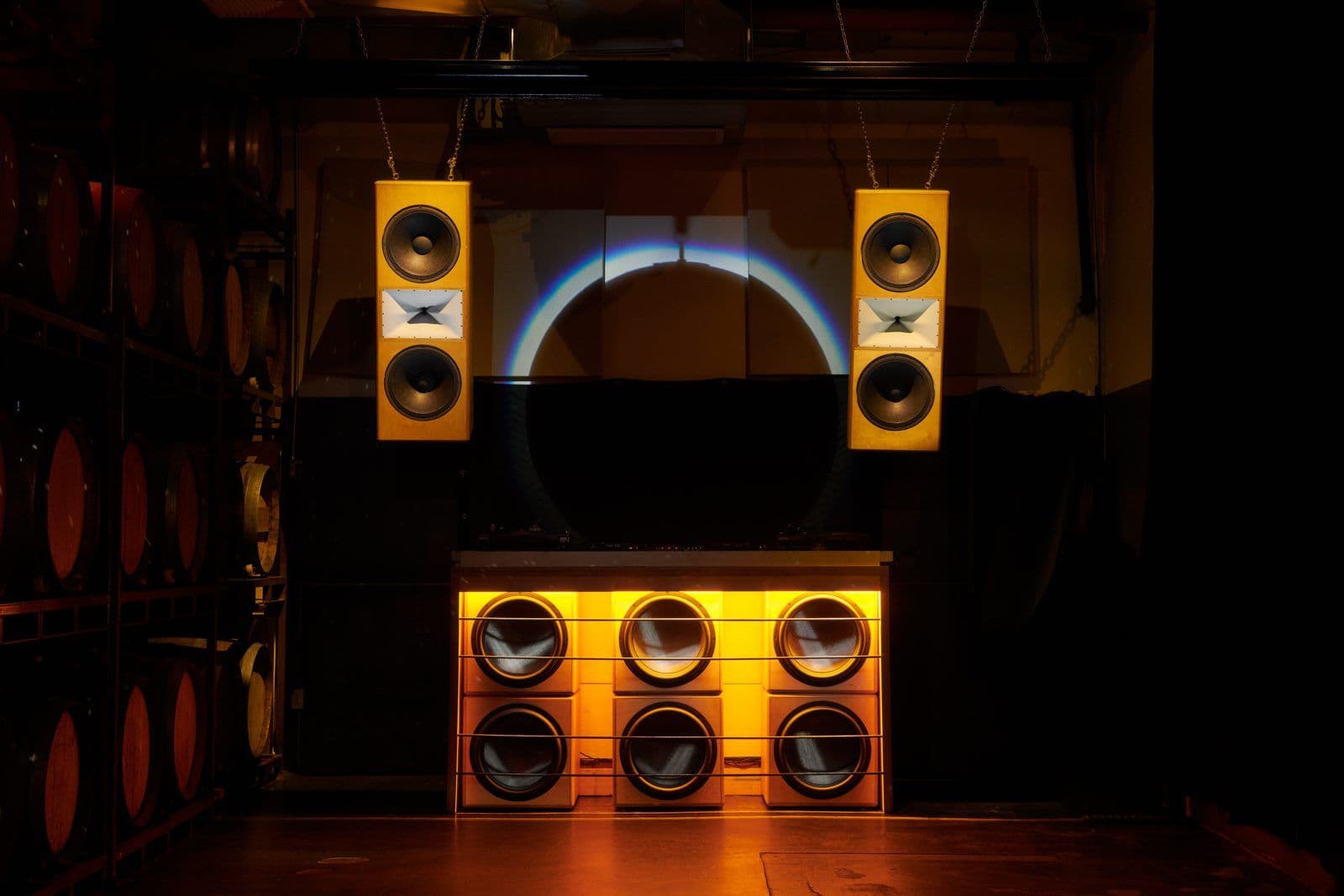 Wide view of a Sound + Color venue install — glowing subwoofers and horns